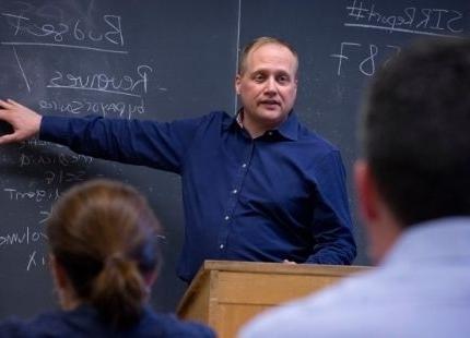 Graduate professor lecturing in front of class